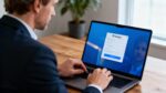 Professionnel européen ajustant les paramètres de confidentialité sur son ordinateur portable avec LinkedIn ouvert